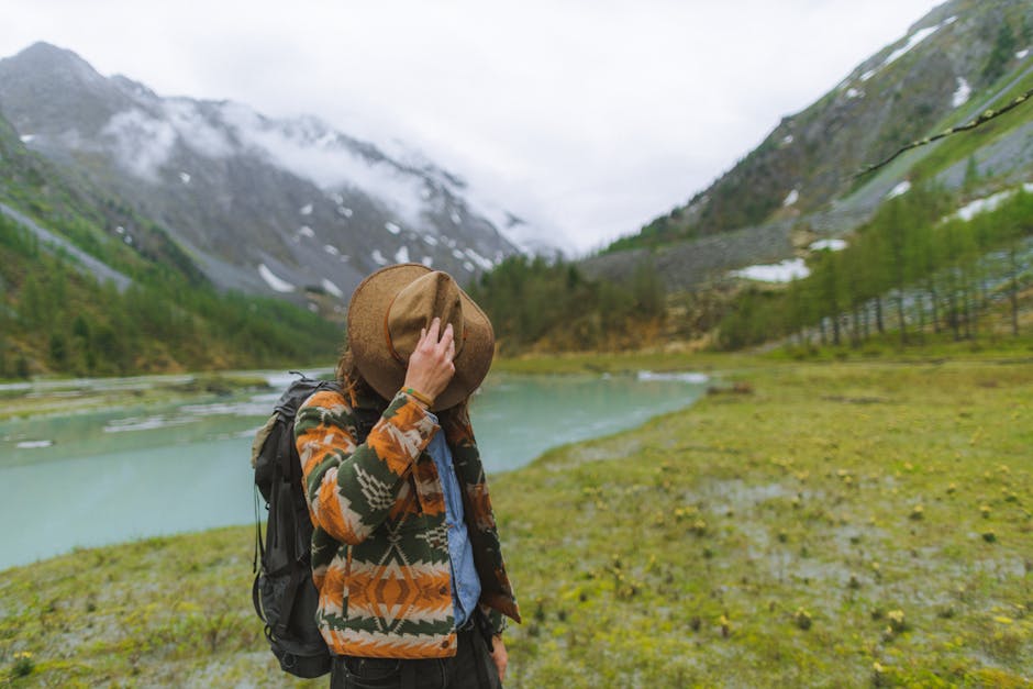 Traveler explores scenic Russian lake and mountains, showcasing nature's beauty.