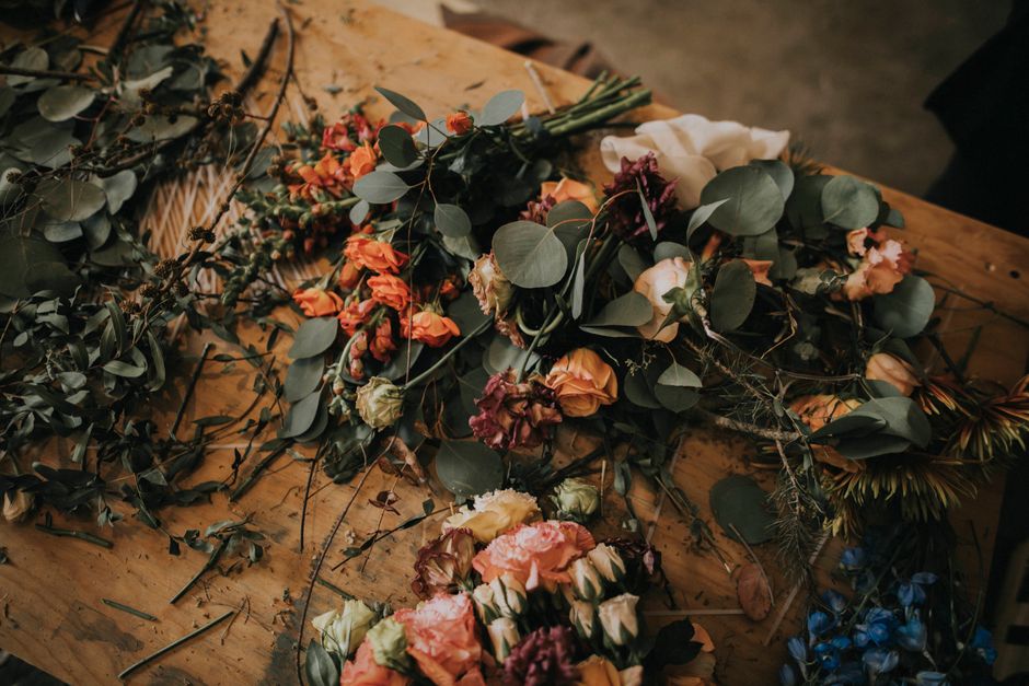 A beautiful array of colorful flowers and leaves on a rustic wooden table, ideal for botanical themes.