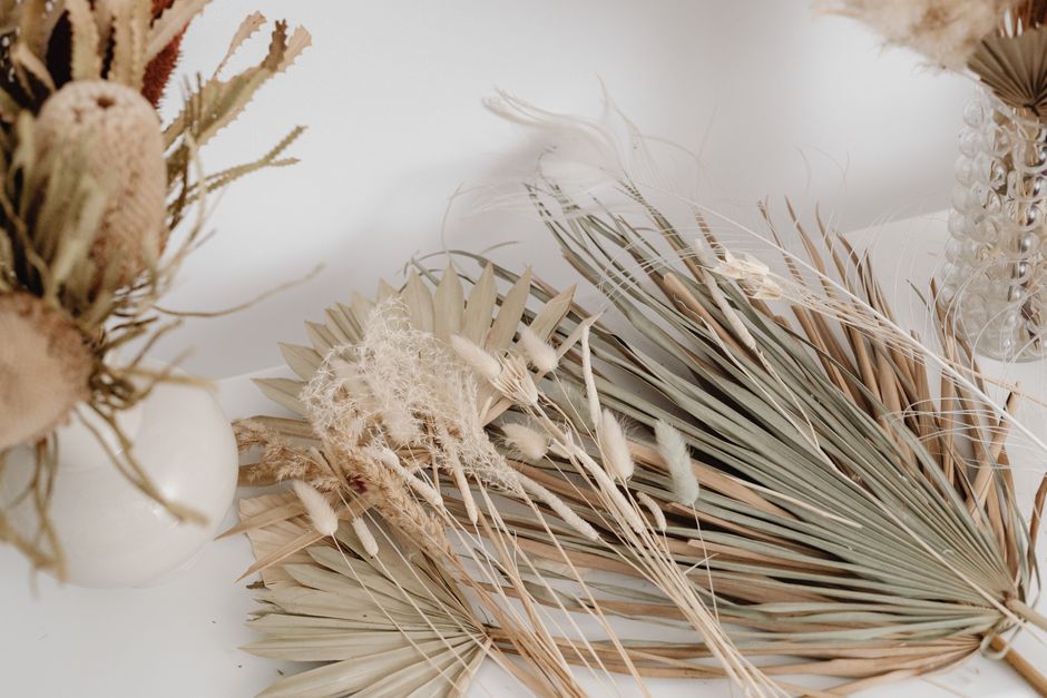 Elegant display of dried palm leaves and floral stems on a white background, perfect for decor.