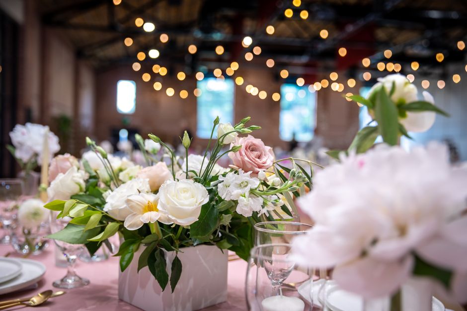 Beautiful floral centerpiece arrangement with roses at a wedding reception table setting.