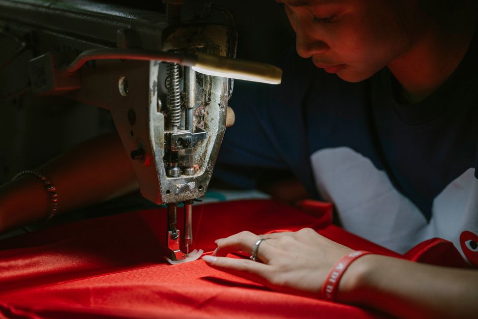 A dedicated seamstress skillfully operates a sewing machine, creating garments with precision and care.
