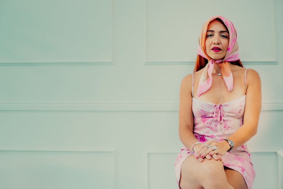 Stylish woman in a pink dress and headscarf, elegance meets modern fashion.