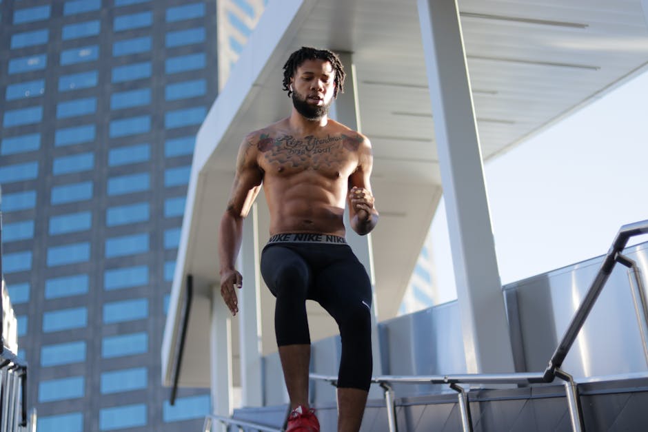 Fit man running shirtless outdoors, showcasing muscular physique during a workout.