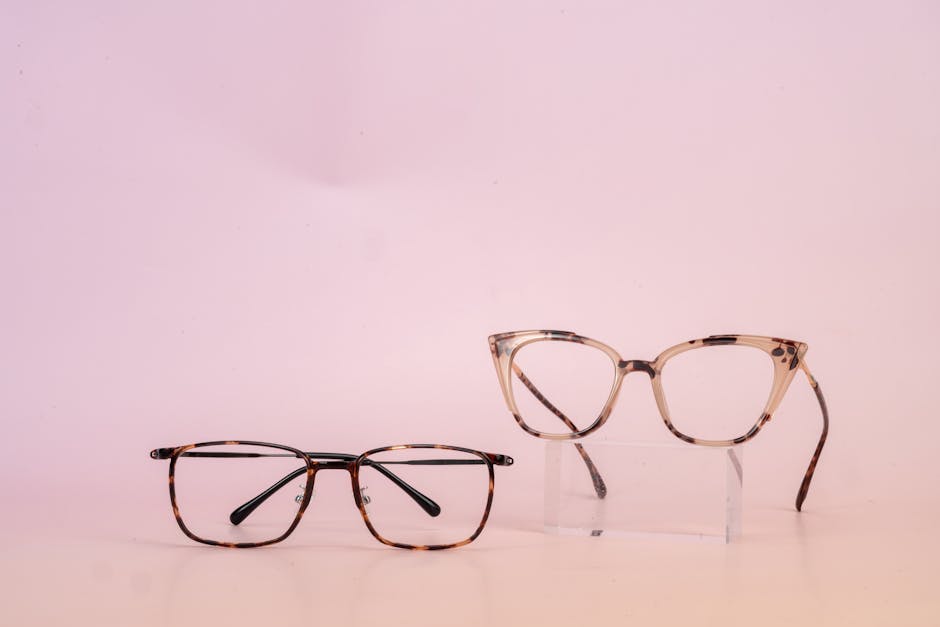 Two stylish glasses on a pink background for modern eyewear fashion.