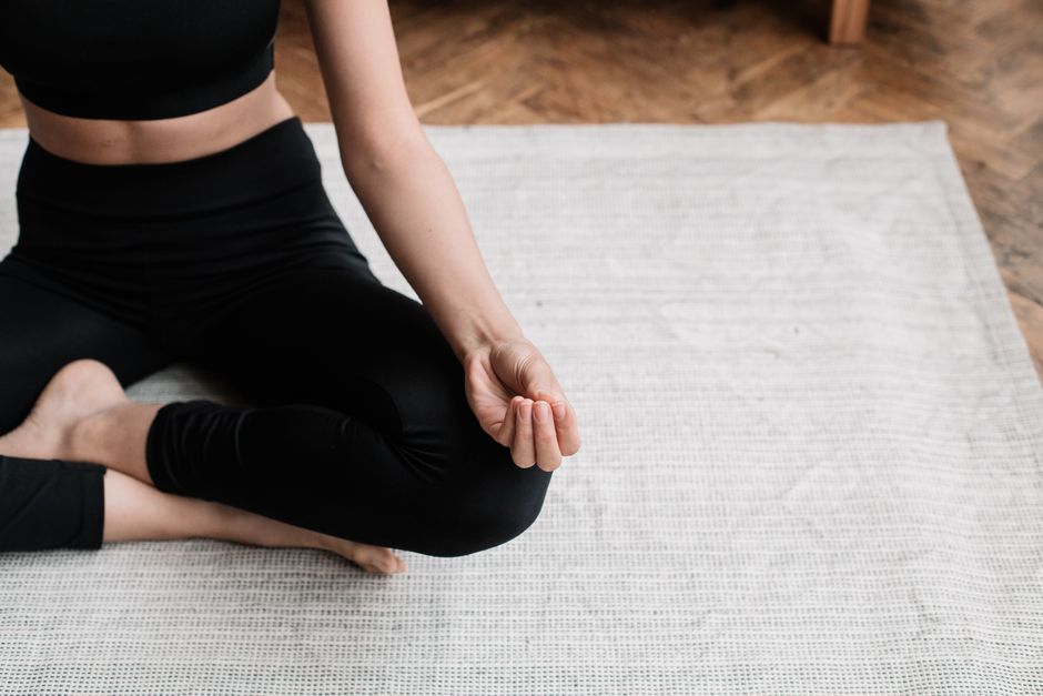 A person meditating indoors, emphasizing relaxation and mindfulness.