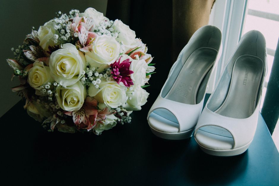 A close-up of a romantic bridal bouquet paired with stylish high heels, perfect for weddings.