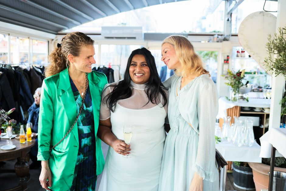 A group of women sharing a joyful moment indoors during a cozy celebration.