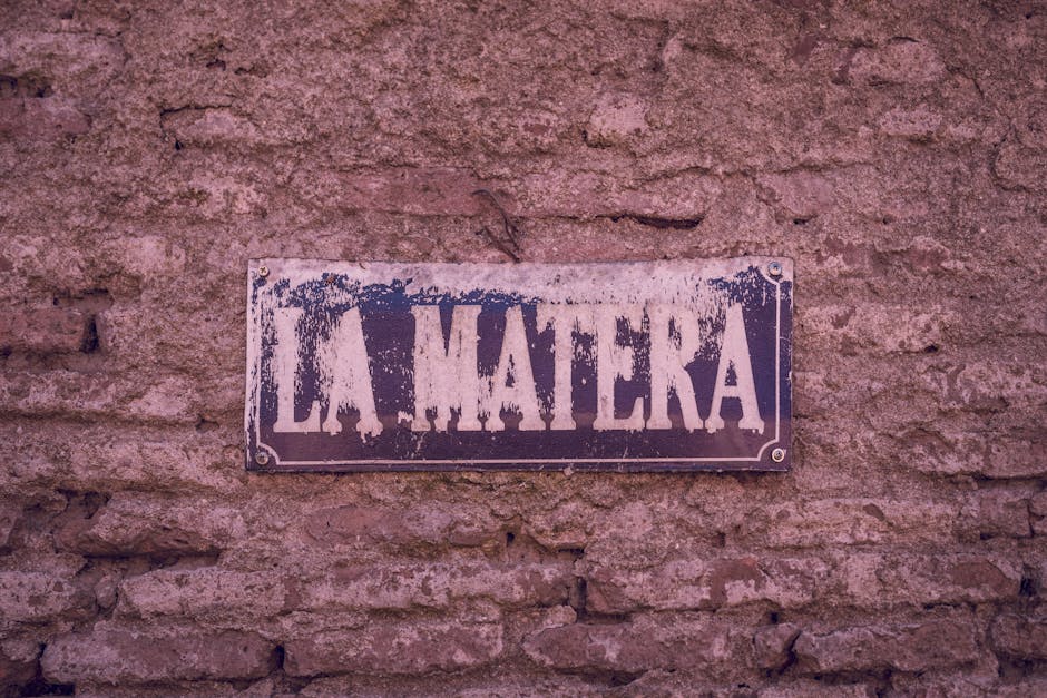 Distressed 'La Matera' sign on rustic brick wall, Chascomús, Argentina.