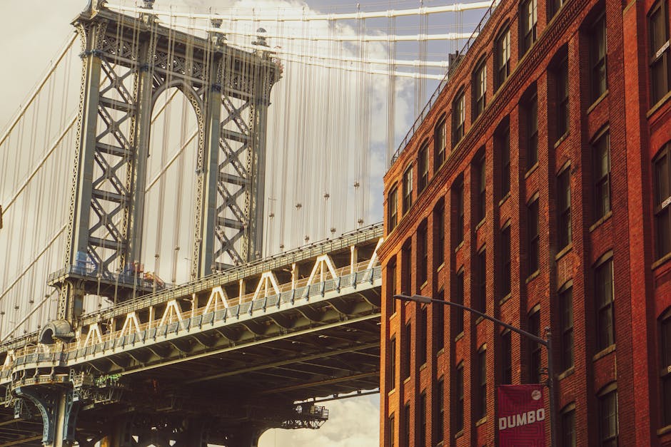 View of Manhattan Bridge adjacent to red brick building in DUMBO, Brooklyn.