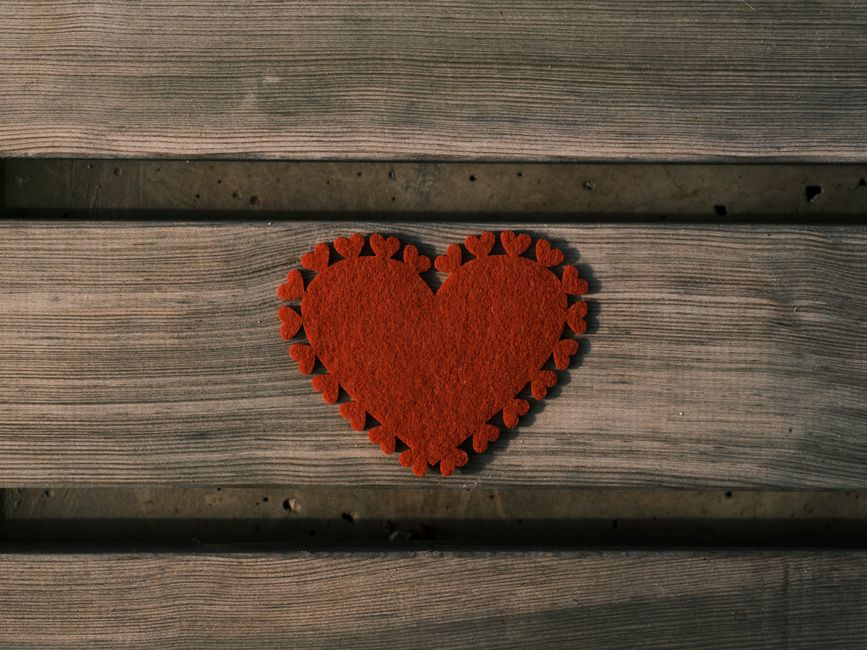 A decorative red heart symbolizing love on a rustic wooden background, perfect for Valentine's Day themes.