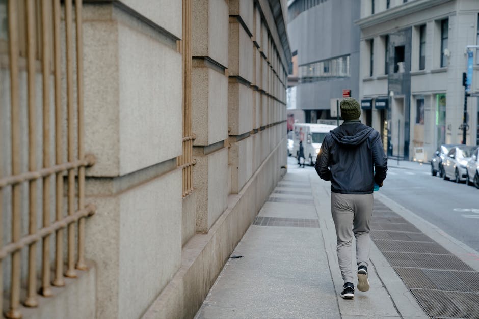 A man jogging along a city street, showcasing urban lifestyle and fitness.